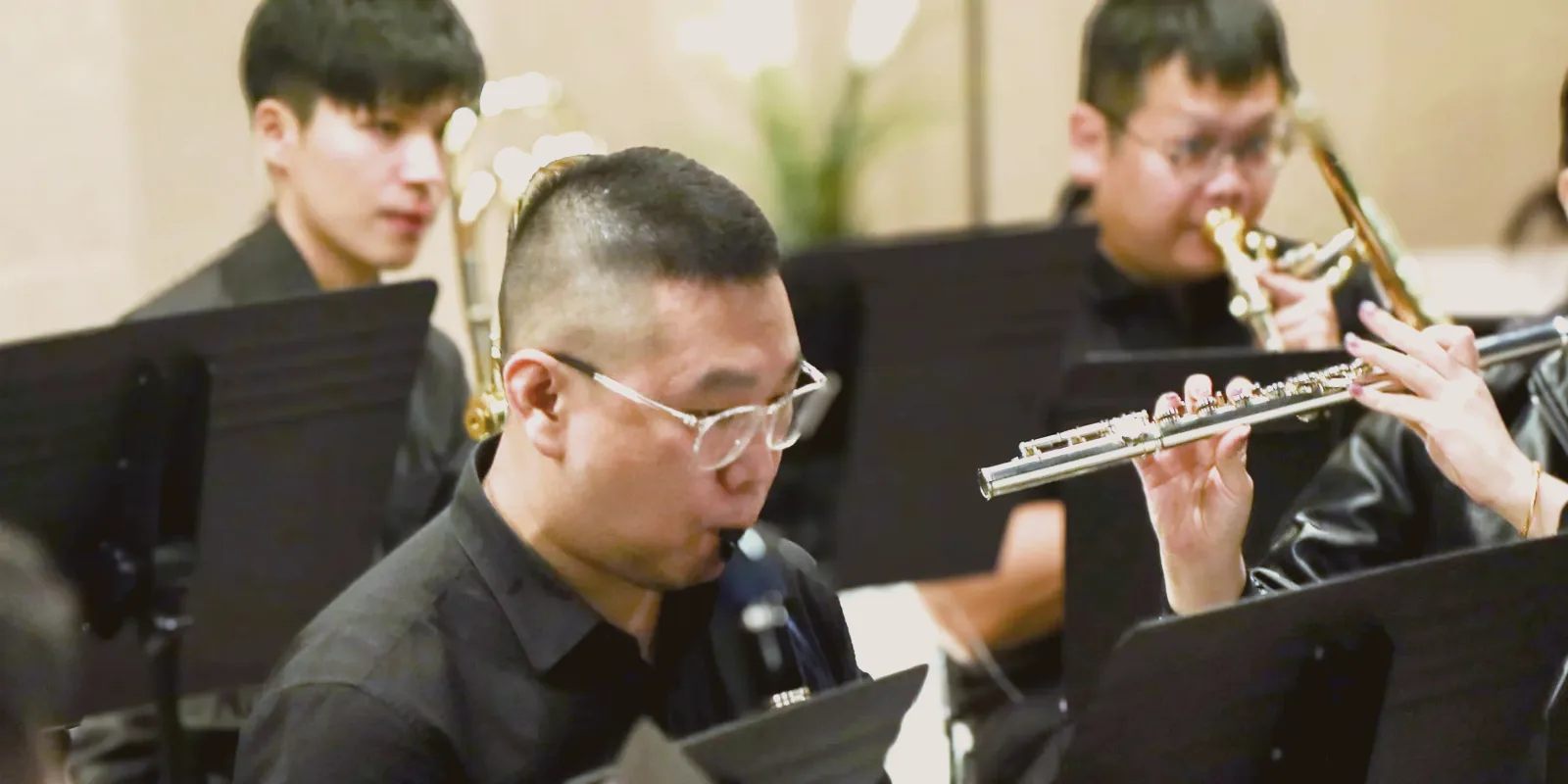 A TWA flautist and clarinettist reading music side by side in rehearsal