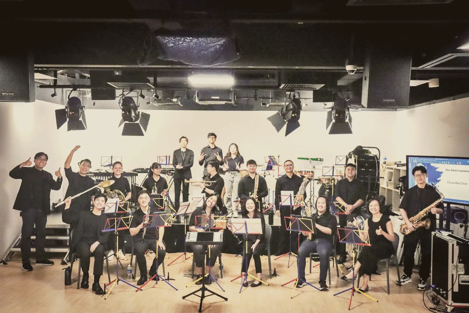 The Wind Academia band on stage after a performance, learners of every age with their instruments