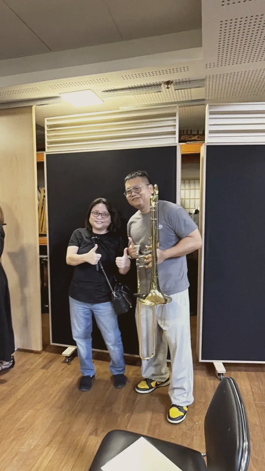 Two TWA band members giving a thumbs up after Finale 2026, one holding a trombone