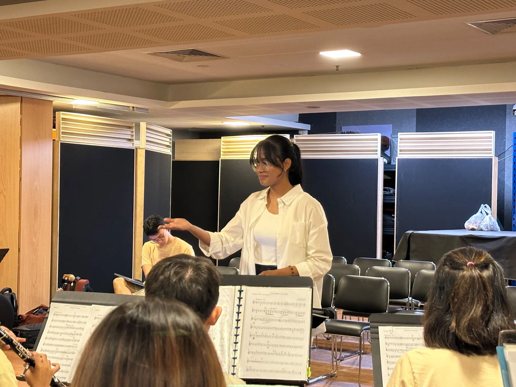 A conductor leading a sectional rehearsal at TWA