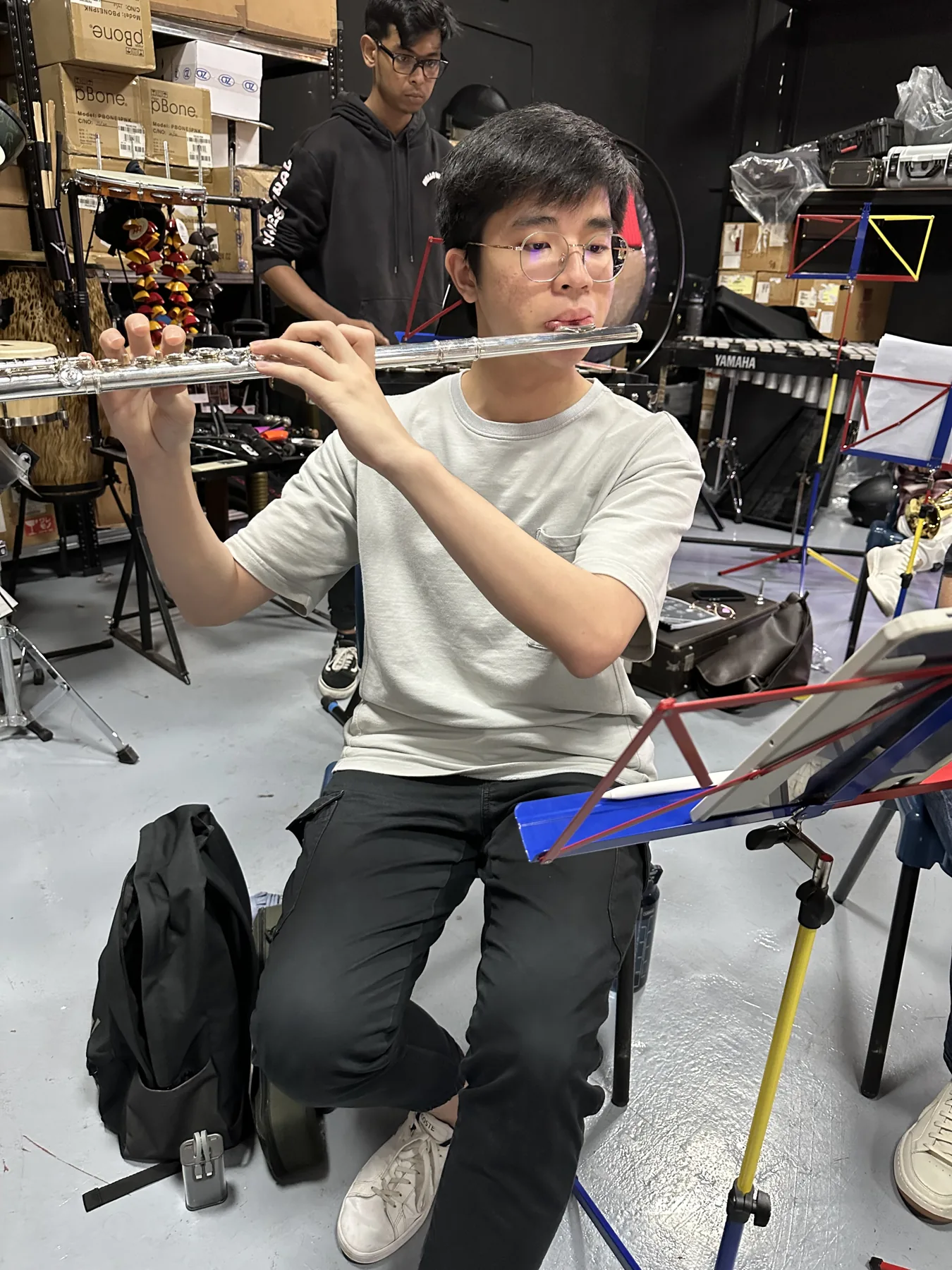 A TWA flautist reading music at a 2024 band rehearsal