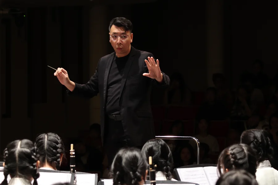 Louis Yeo conducting a TWA band on stage