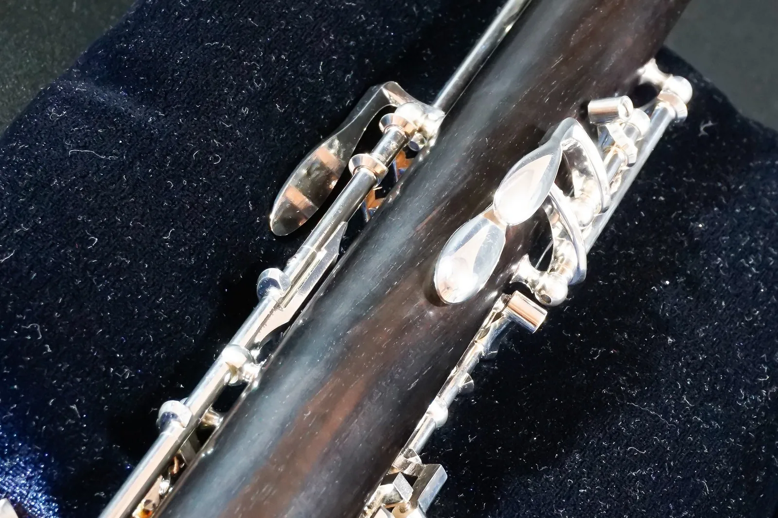 Close-up of the silver keys on a black oboe
