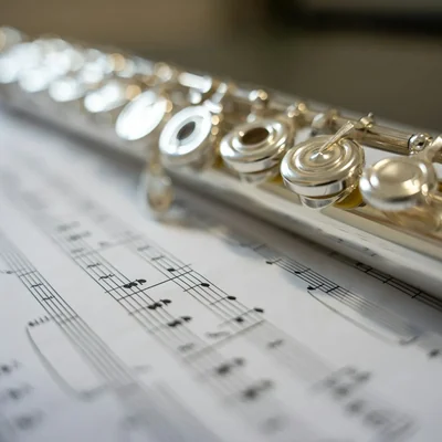 A silver flute resting on sheet music