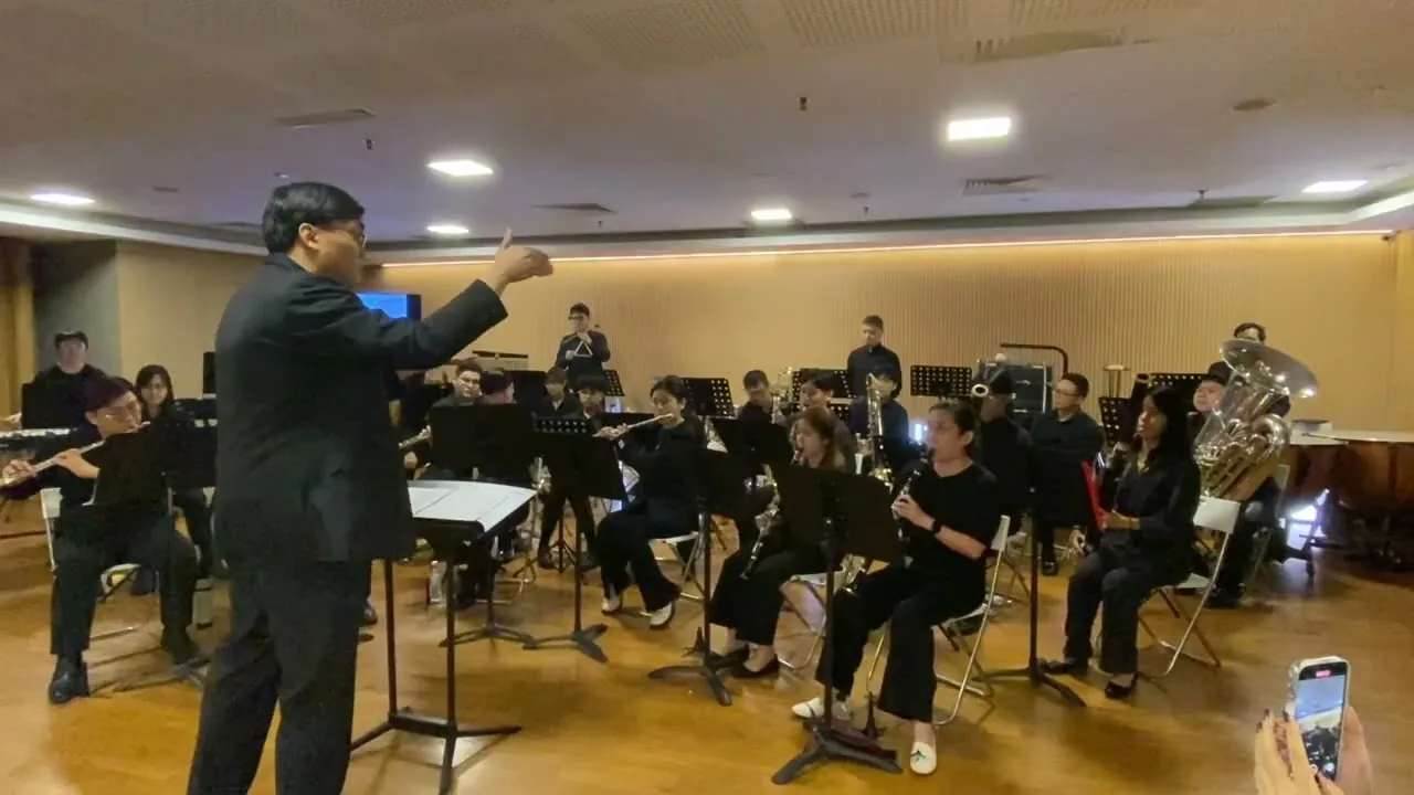 Louis Yeo conducting the TWA band in black at the Finale 2025 concert