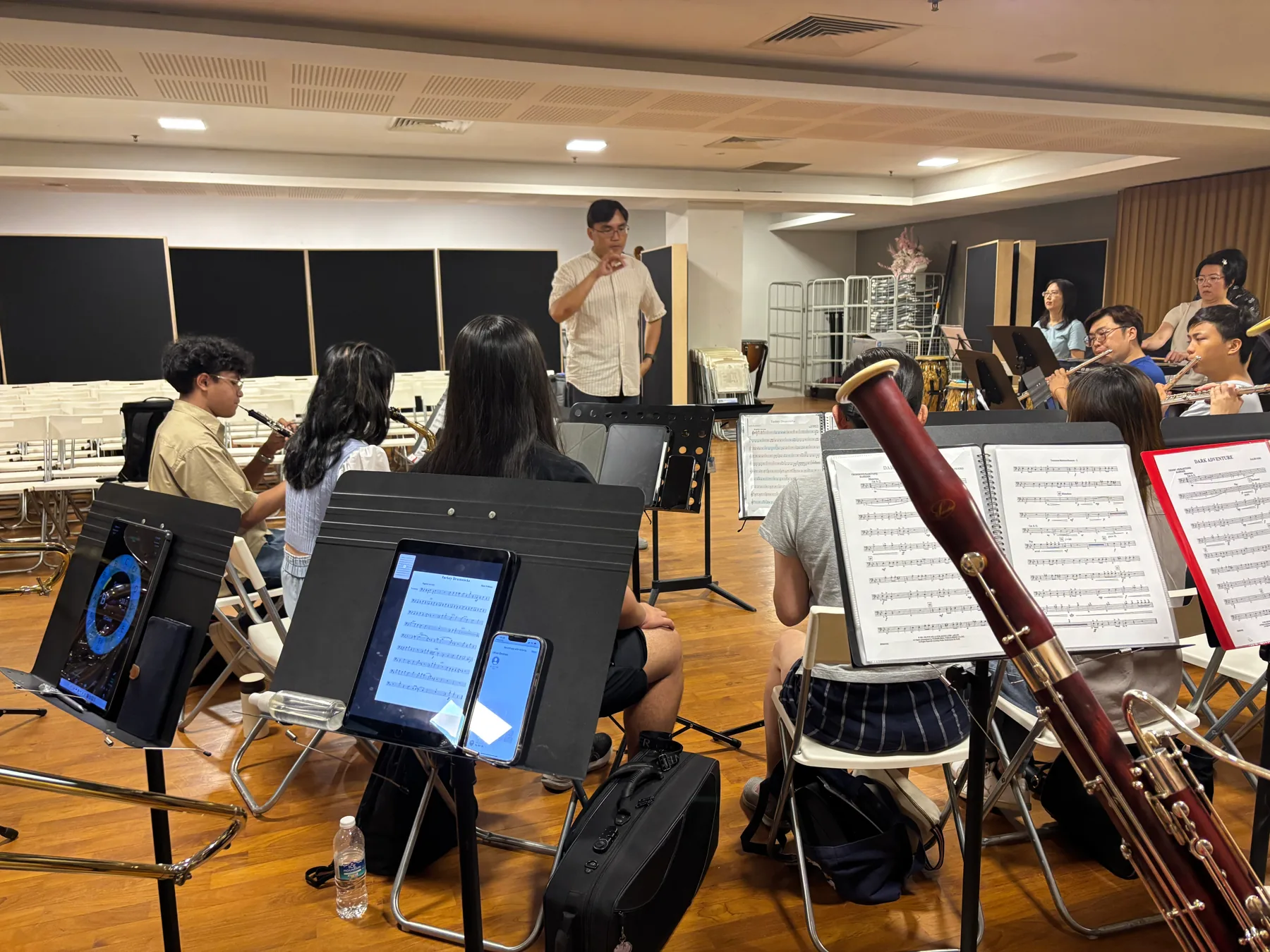 The conductor leading TWA woodwind players in rehearsal